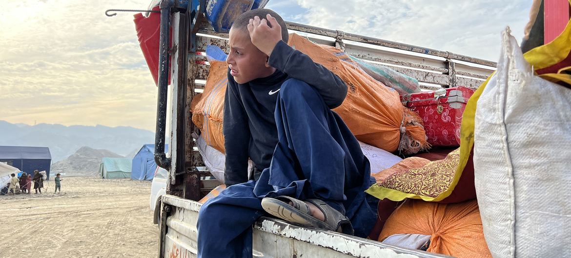 A boy in a truck carrying his family’s possessions waits to return to Afghanistan.